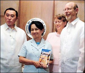 Philippine president Gloria Macapagal-Arroyo with Agriculture Secretary Arthur Yap acknowledges the efforts of author Bruce Fife (with wife Leslie) in dispelling decades of misinformation about coconut and helping revive the coconut industry in the Philippines, which provides for the livelihoods of over 20 million people in that country. Dr. Fife presented president Macapagal-Arroyo with a copy of his new book Coconut Cures.